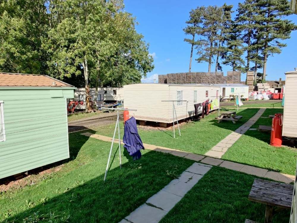 Жилые караваны сезонников на газоне с дорожками на ферме Woodfields